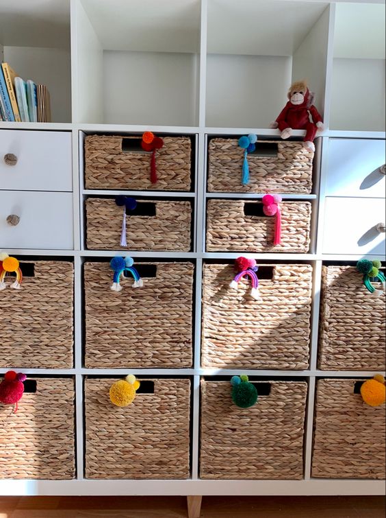 An Ikea Kallax Piece With Woven Drawers And Colorful Pompoms Is An Awesome Furniture Piece For A Kid's Room