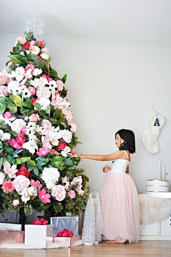 a gorgeous Christmas tree decorated with white, blush and red blooms and magnolia leaves plus a snowflake topper