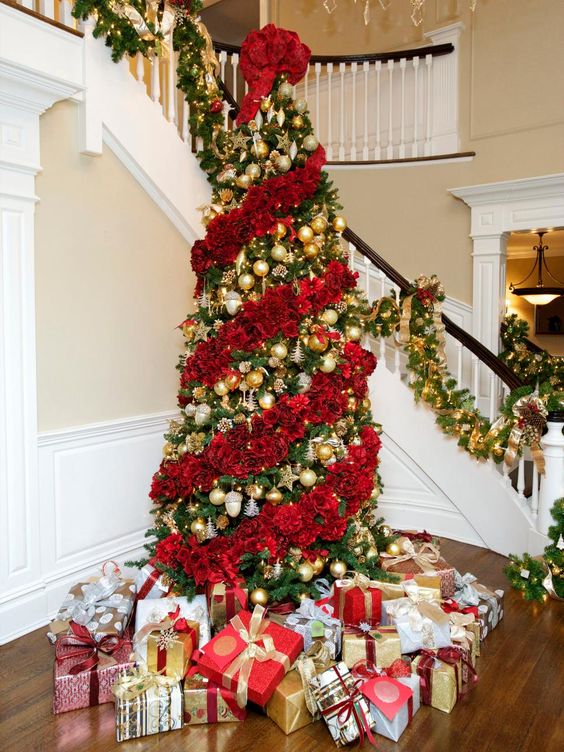 a jaw-dropping Christmas tree decorated with red roses and gold ornaments in between floral garlands is magnificent