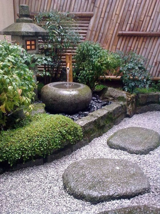 pebbles, rocks, grass, shrubs, a stone bowl fountain and a stone lantern for a lovely and chic Japanese front yard